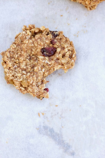 A breakfast cookie with a bite missing on parchment paper