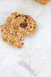 A breakfast cookie on parchment paper with a bite out of it