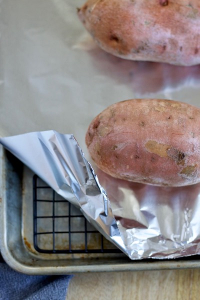 the baking pan set up for baked sweet potatoes is a rimmed baking sheet, a cooling rack, and a piece of tin foil