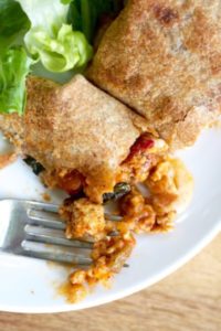 Veggie-packed baked burritos are stuffed with a hearty filling and baked to crispy perfection - and make an awesome freezer meal!