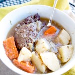 a bowl of pot roast with tender meat, potatoes, and carrots