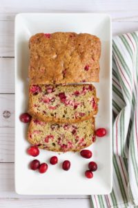 A thick slice of moist fresh cranberry bread, bursting with tart berries, and slathered with butter.