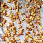 a foil-lined sheet pan with life-changing super crispy roasted potatoes scattered on it