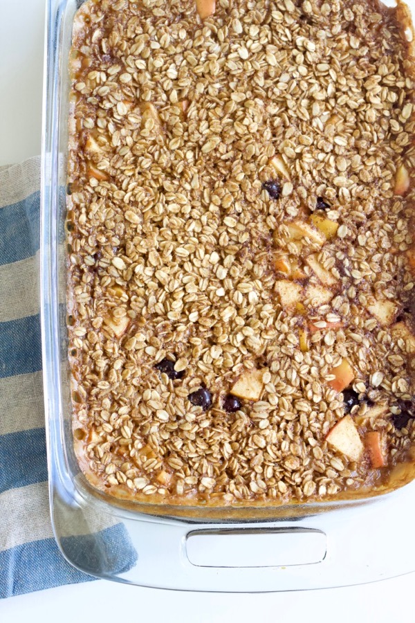 a pan of baked oatmeal with apples and blueberries